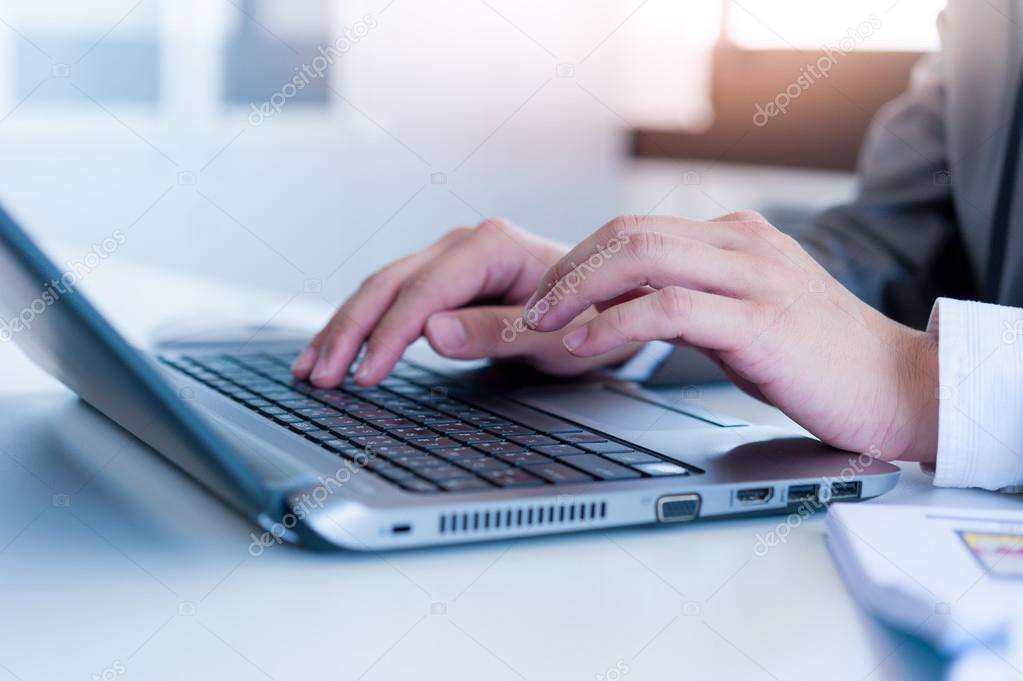 Close up of business man hands typing on laptop conputer