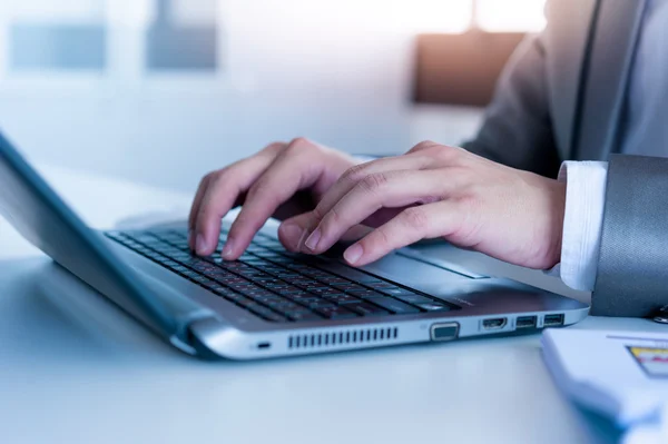 Hombre de negocios escribiendo en el ordenador portátil con efecto de capa de tecnología — Foto de Stock