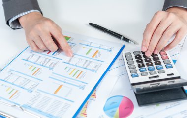 İşadamı hesap makinesi kullanarak analiz raporu