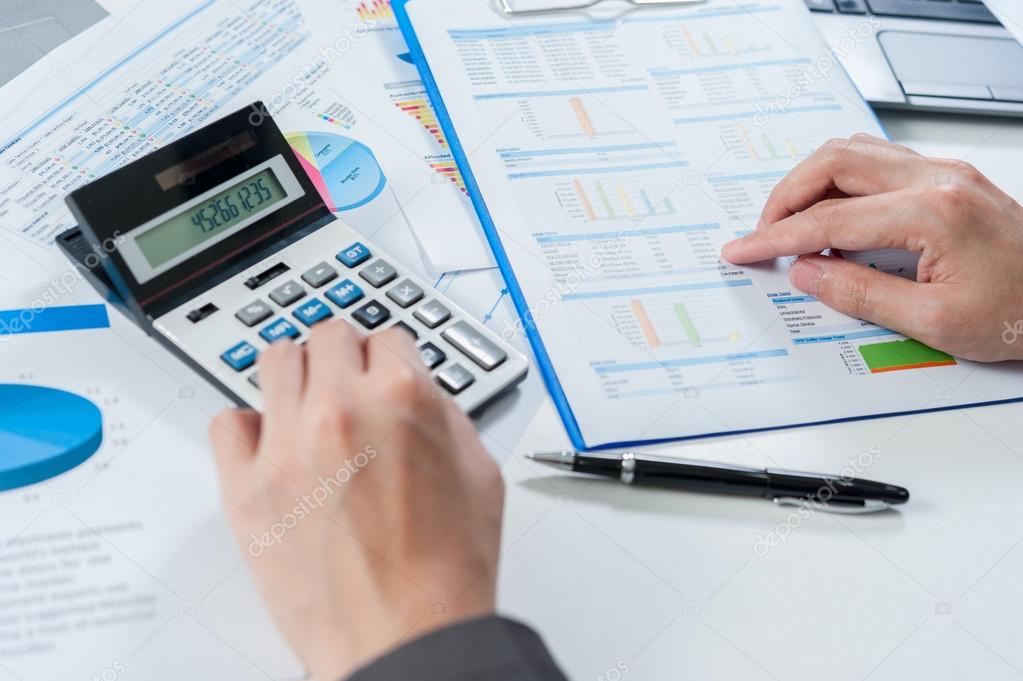 Businessman using calculator analyze report