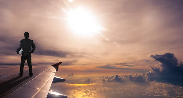 Liikemies, jolla on turvakypärä lentokoneen siivessä, suc — kuvapankkivalokuva