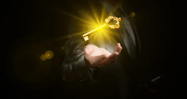 Business man hold a gold shining key, business concept — стоковое фото