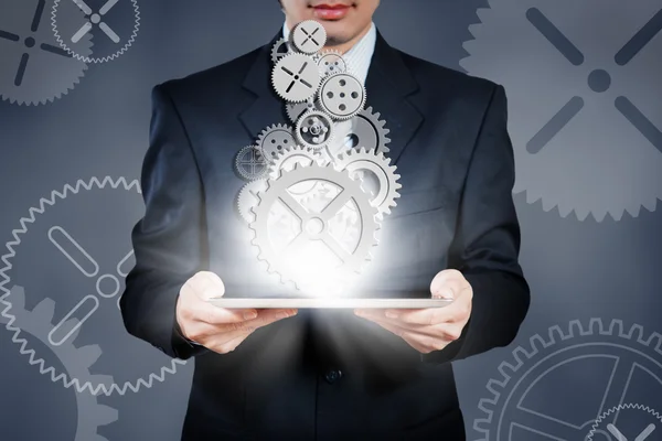 Businessman holding tablet showing gears, business strategy conc — Stock Photo, Image