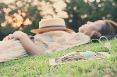 Young woman taking a nap in park, vintage style clipart