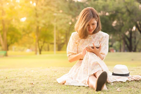 Junge Frau benutzt Tablet im Park — Stockfoto