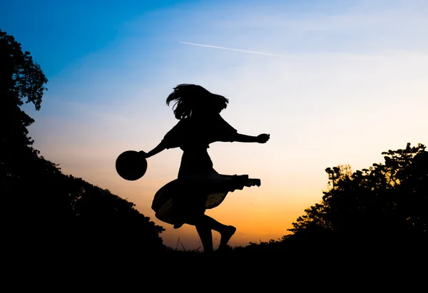 Silhouette girl playing in park at sunset — Stock Photo, Image