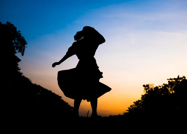 Silhouette girl playing in park at sunset — Stock Photo, Image