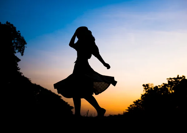 Silhouette Mädchen spielt im Park bei Sonnenuntergang — Stockfoto