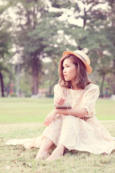 Vintage Girl sentarse en el parque escuchar música a través de una pequeña charla —  Fotos de Stock