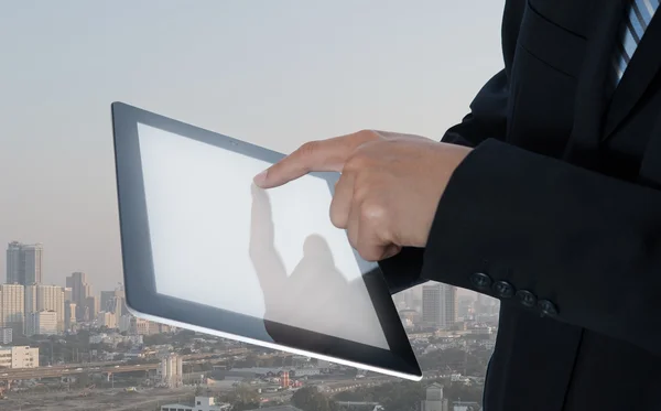 Empresário usar tablet com paisagem urbana no fundo — Fotografia de Stock