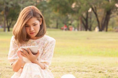 Genç kadın parkta tablet kullanma