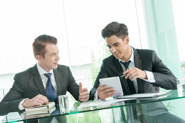 Dos hombres de negocios usando tableta en la reunión — Foto de Stock