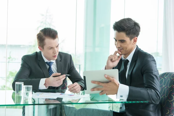 Dos hombres de negocios usando tableta en la reunión — Foto de Stock