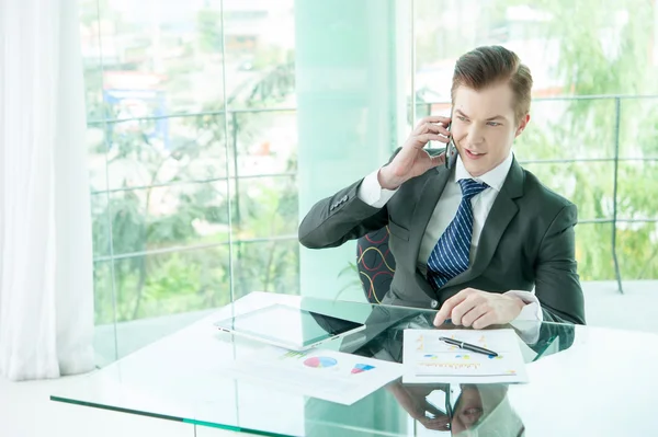 Hombre de negocios guapo de traje hablando por teléfono en la oficina — Foto de Stock