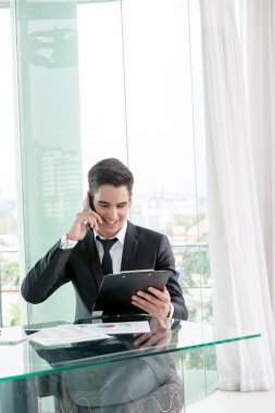 ofiste cep telefonu üzerinden konuşurken işadamı