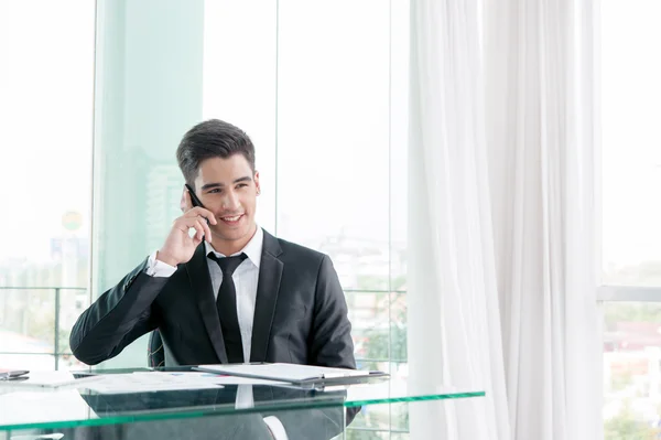 Hombre de negocios hablando por teléfono celular en la oficina — Foto de Stock