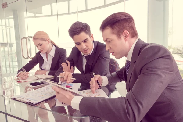 Affärspartners diskuterar dokument och idéer vid mötet — Stockfoto