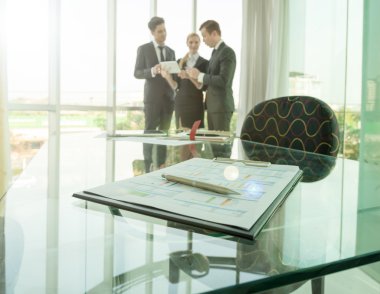 İş ortakları toplantıda belge ve fikirleri tartışıyor