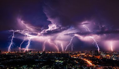 Lightning storm over city in purple light clipart