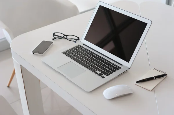 Laptop com smartphone e livro de notas na mesa de trabalho — Fotografia de Stock