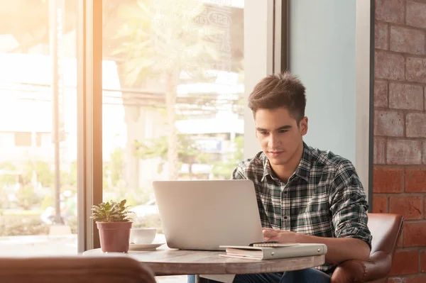 Uomo d'affari che utilizza laptop con tablet e penna su tavolo in legno in — Foto Stock