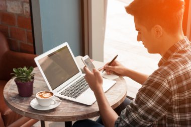 Smartphone ve tablete yazma dizüstü kullanarak iş adamı woo