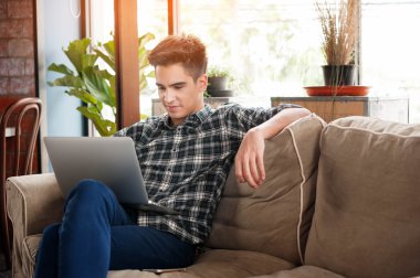 Divan kafede dizüstü kullanarak iş adamı