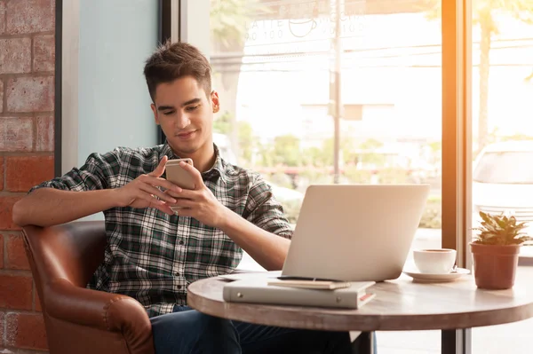 Businessman using smartphone and laptop with tablet and pen on w — Stock Photo, Image