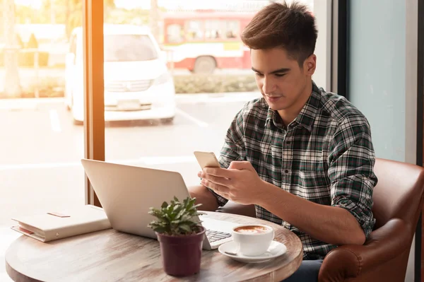 Empresario usando smartphone y laptop escribiendo en tableta en woo — Foto de Stock