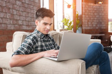 Divan kafede dizüstü kullanarak iş adamı