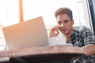 Cep telefonu karşıkarşıyayız laptop süre üzerinde ahşap kullanarak iş adamı