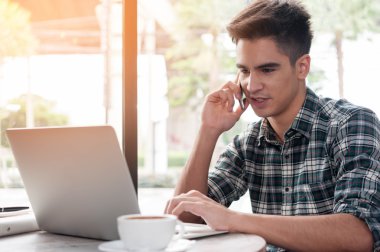 Cep telefonu karşıkarşıyayız laptop süre üzerinde ahşap kullanarak iş adamı