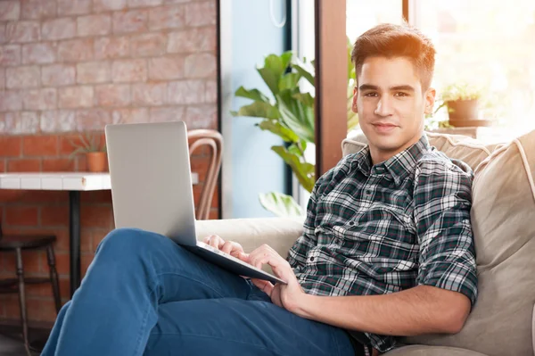 Бізнесмен використовує ноутбук на дивані в кав'ярні — стокове фото
