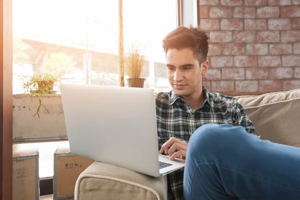 Zakenman met behulp van laptop op sofa in koffie shop — Stockfoto