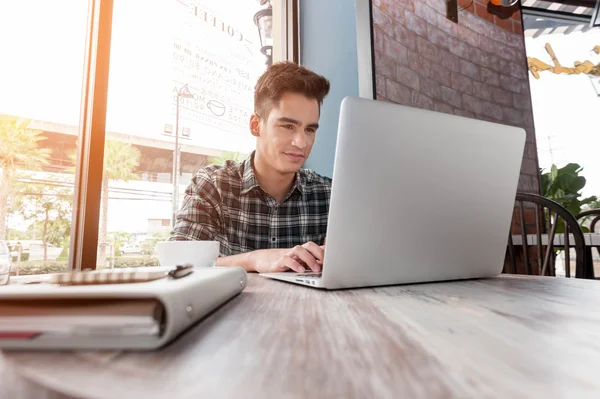 Empresario con portátil en mesa de madera en cafetería — Foto de Stock