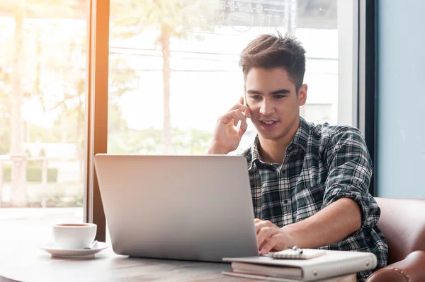 Podnikatel, používání mobilního telefonu při lookingat notebook na dřevěné — Stock fotografie