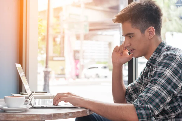 Zakenman met behulp van mobiele telefoon terwijl lookingat laptop op houten — Stockfoto