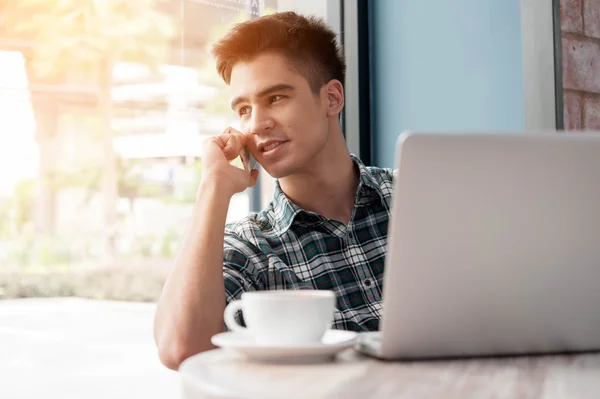 Zakenman met behulp van mobiele telefoon terwijl lookingat laptop op houten — Stockfoto