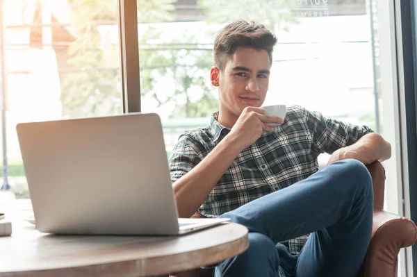 Zakenman drinken koffie met laptop op houten tafel in koffie — Stockfoto