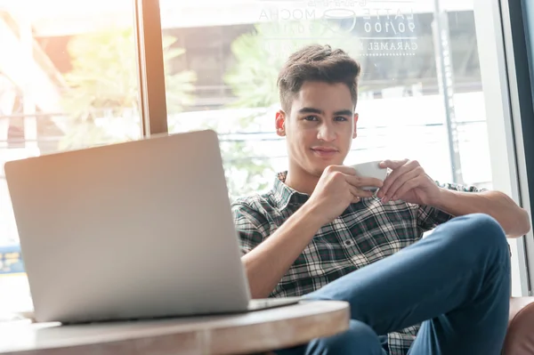 Zakenman drinken koffie met laptop op houten tafel in koffie — Stockfoto