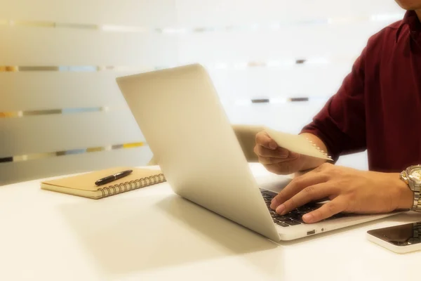 Bijgesneden shot van een jonge man laptopcomputer gebruikt met een stuk o — Stockfoto