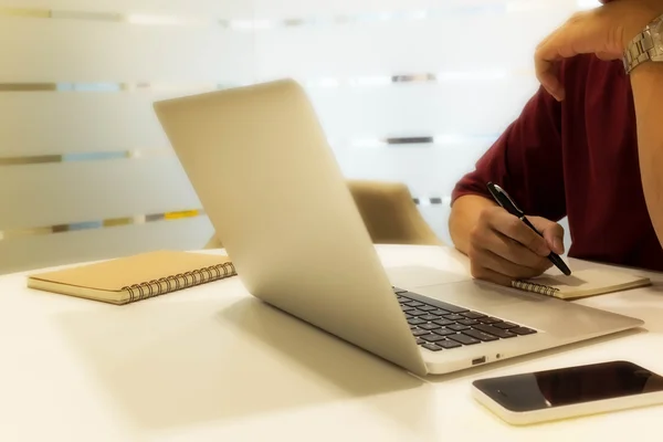 Bijgesneden shot van een jonge man schrijven notitie met laptopcomputer, m — Stockfoto