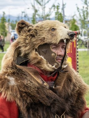 Targu Jiu, Gorj, Romanya 24 Mayıs 2025: Rhabon Festivali 'nde ayı kostümlü antik savaşçı. 