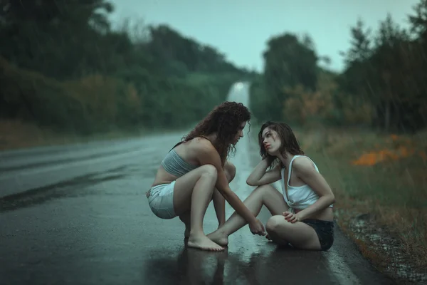 Las mujeres pelean bajo la lluvia en el camino . — Foto de Stock