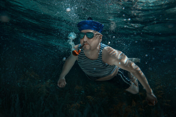 Seaman swims under water.