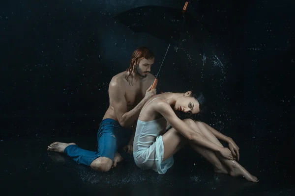 Homem e uma mulher debaixo de água gotas . — Fotografia de Stock