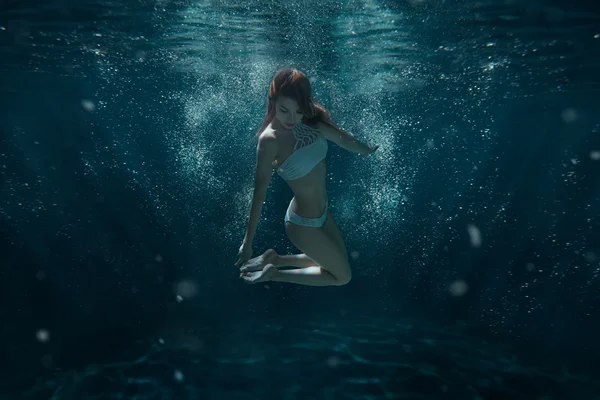 Woman in swimsuit swims under water. — Stock Photo, Image