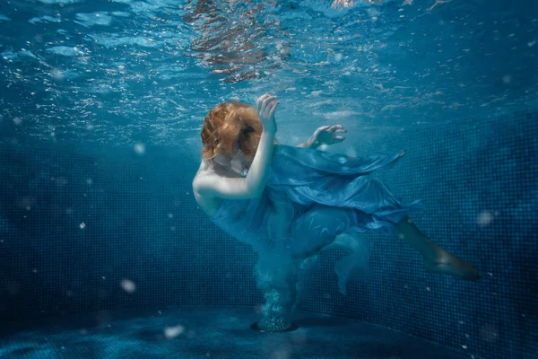 Mädchen im Kleid auf dem Boden des Pools. — Stockfoto