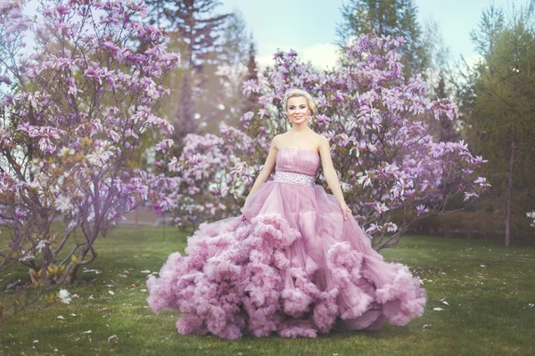 Donna bionda tra alberi in fiore . — Foto Stock