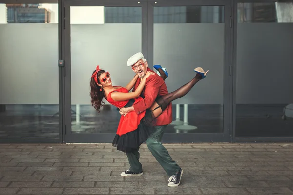 Old man dancing with a young woman. — Stock Photo, Image